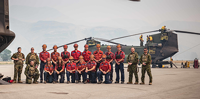 Wildfire crew in front of a helicopter.