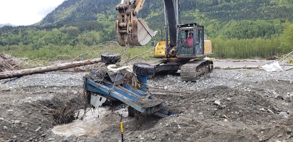 A boom lift is removed from sediment along the Chilliwack River