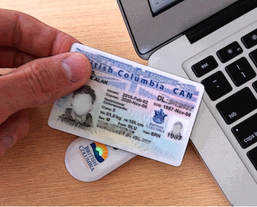 Person tapping a BC services card on computer dongle