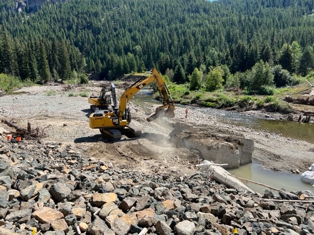 Two excavators remove debris from the Coldwater River
