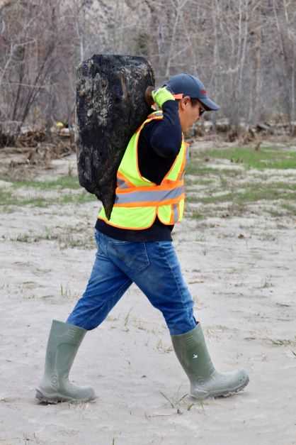 A crew member removes woody debris from waterway