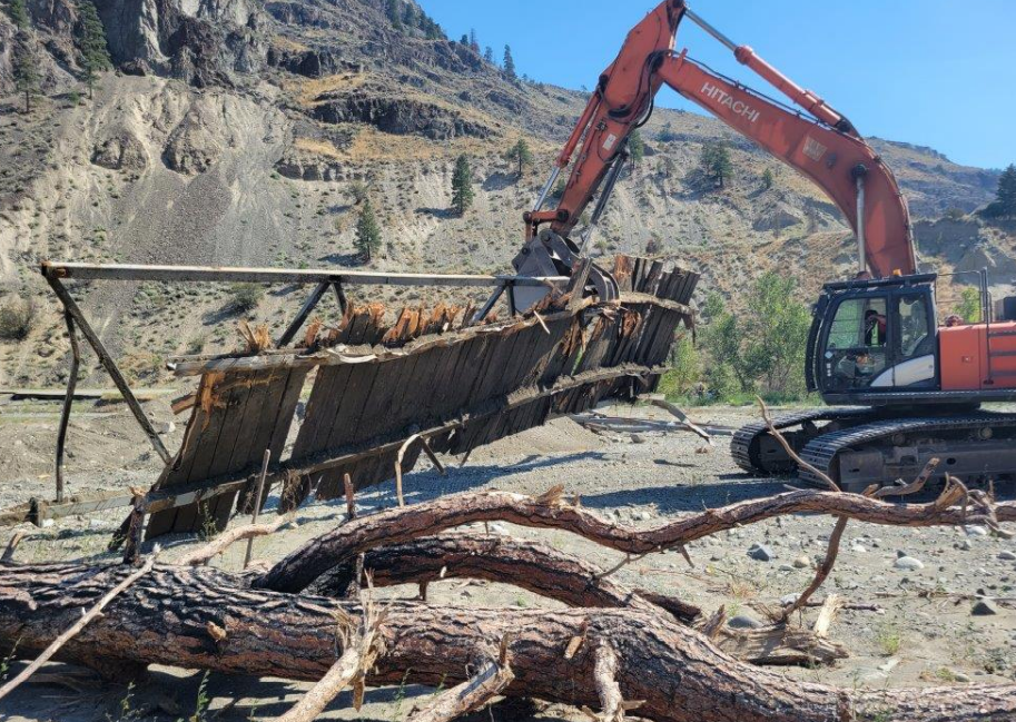 An excavator is used to remove bridge parts from the Nicola River