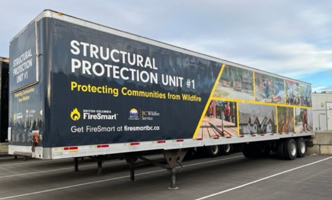 Large black and yellow trailer reading "structural protection unit #1" and parked in a paved lot