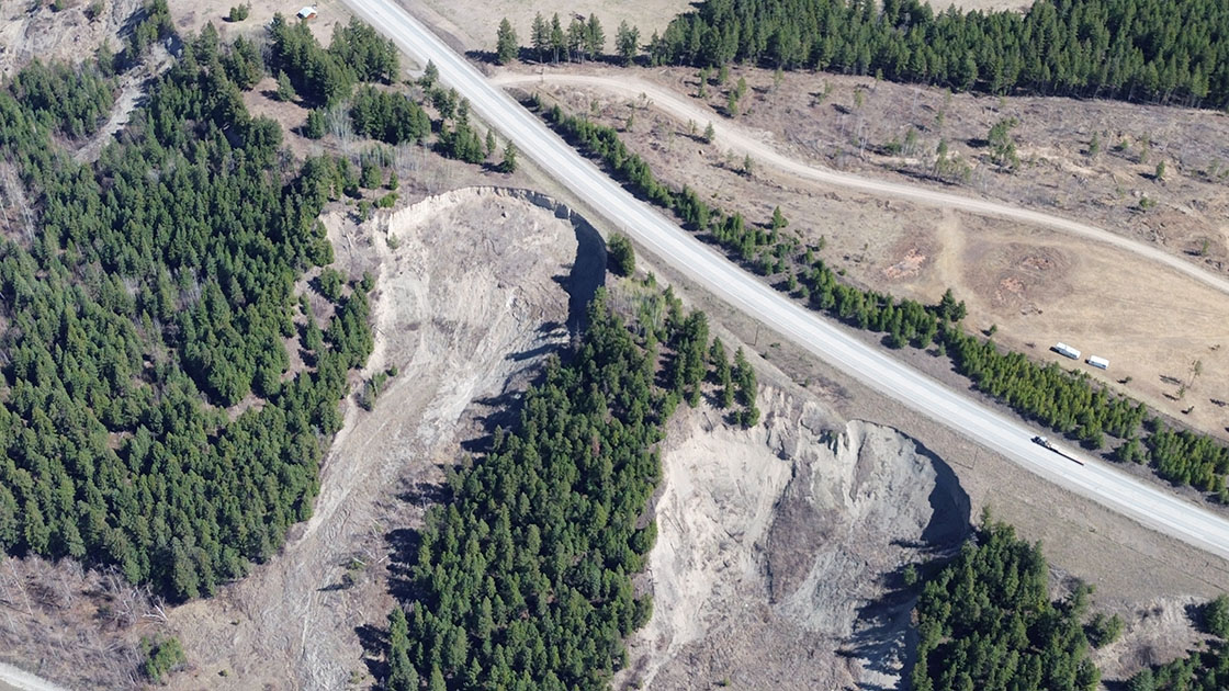 An aerial photo of Highway 97 at Cuisson Creek shows slide damage from April 2021. The project team was on-site carrying out inspections. April 2024