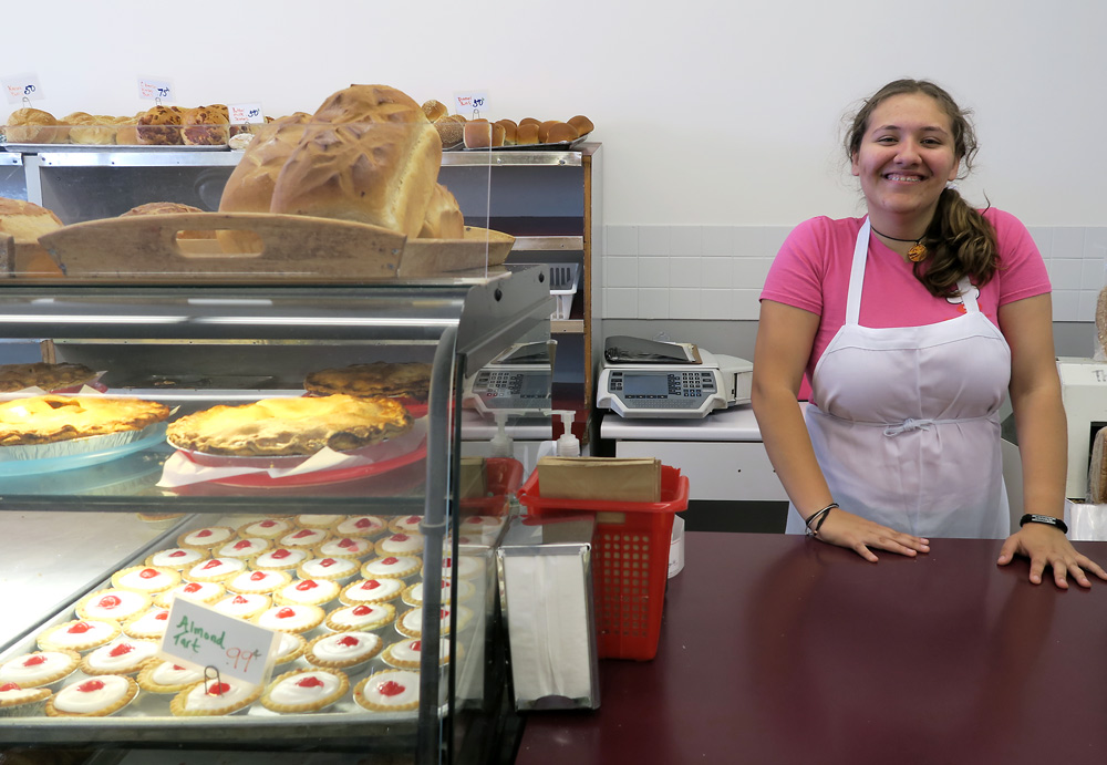 Smiling woman behind a bakery counter