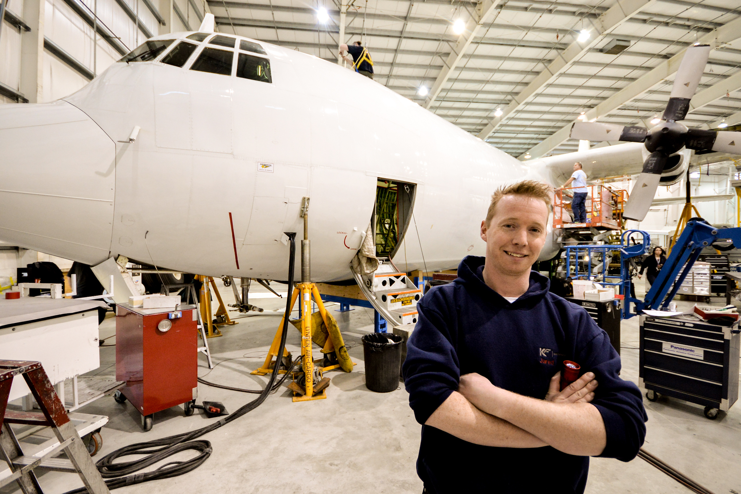 Man standing in front of an airplane being built in an hangar
