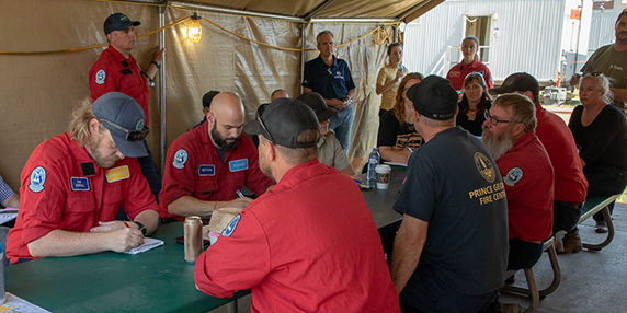 An incident management team meets at a wildfire incident