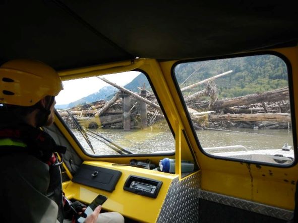A boat crew assesses a large log jam on the Fraser River.