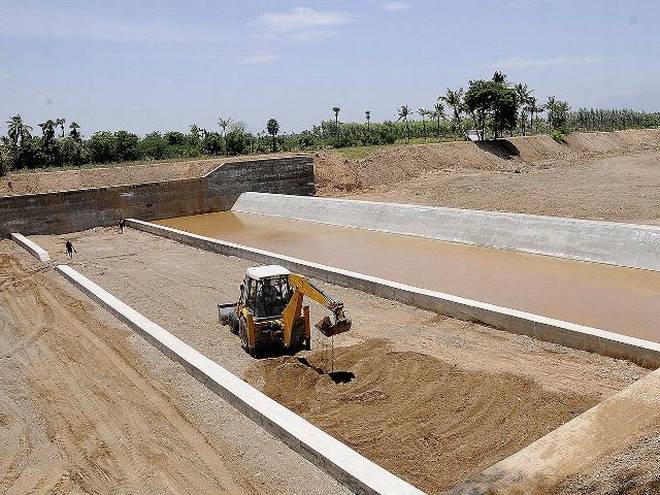 Excavator digging into foundation to prepare dam construction