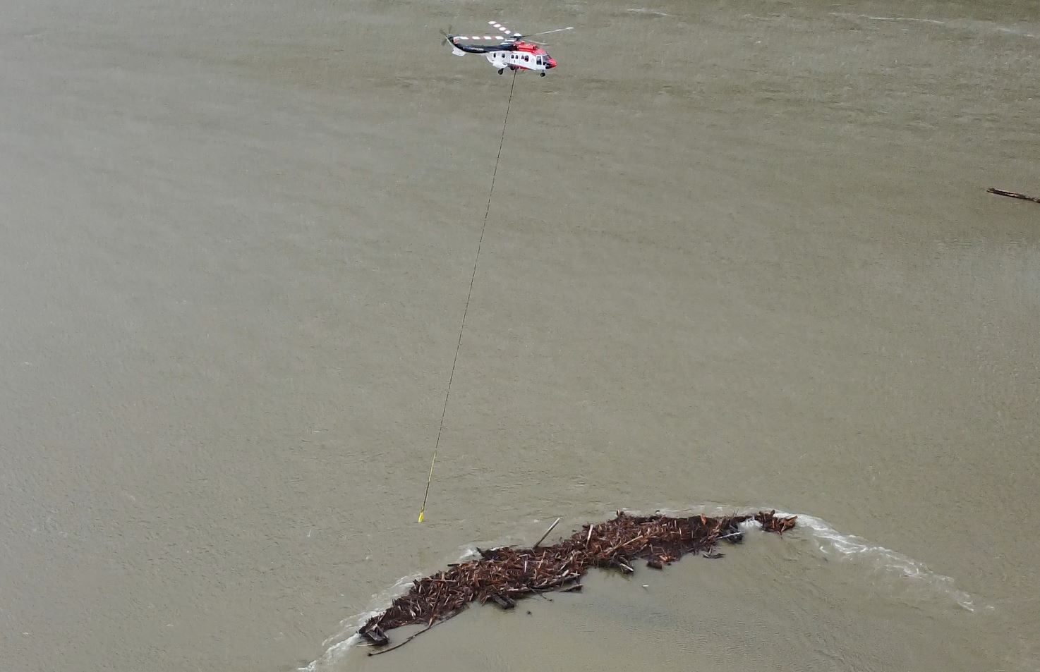 A helicopter removes debris from Fraser River