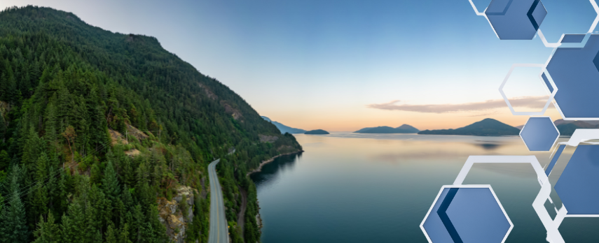 A remote BC road alongside a body of water, with the sun setting over islands in the distance
