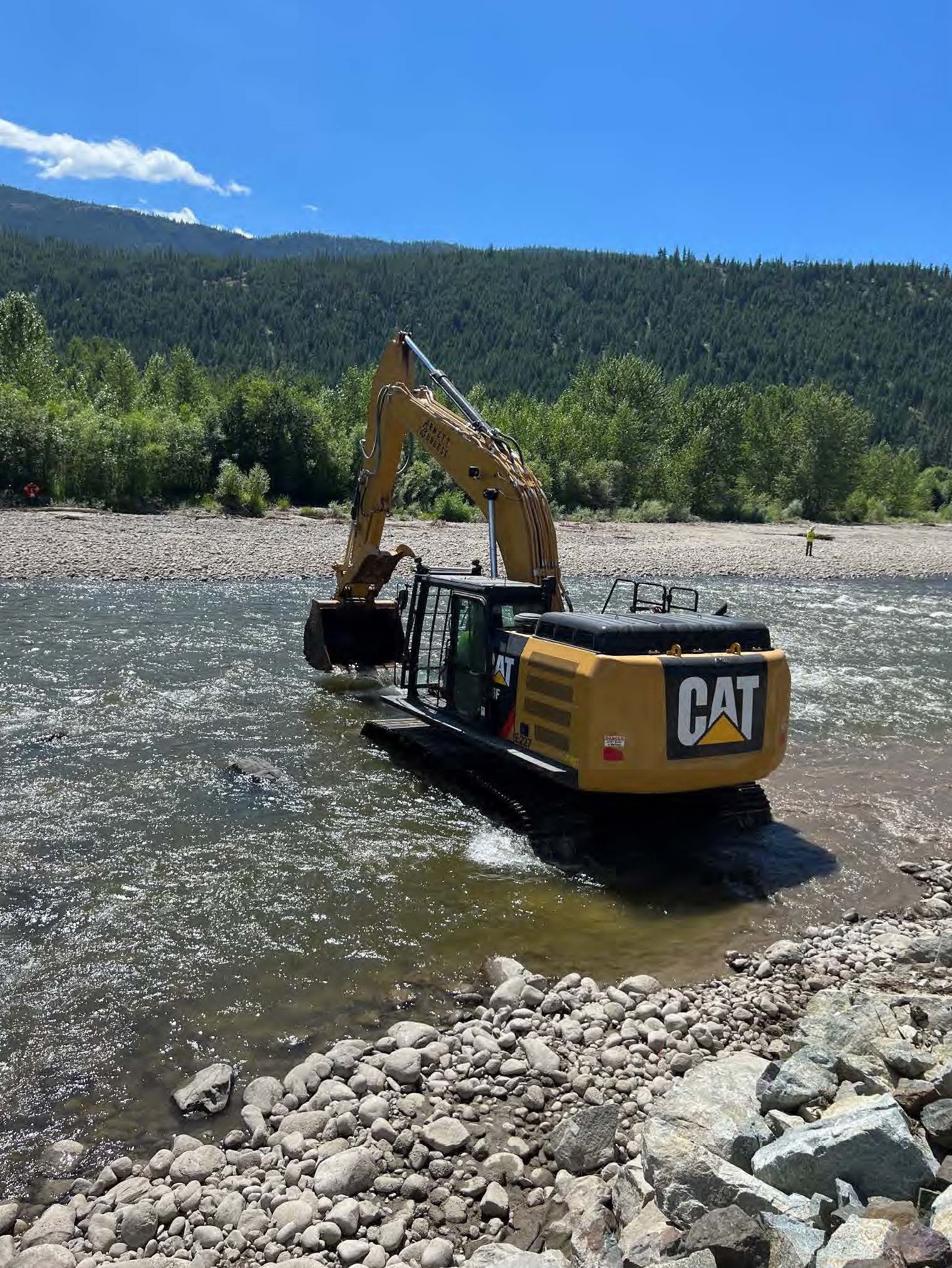 An excavator removes vehicle parts from the Nicola River