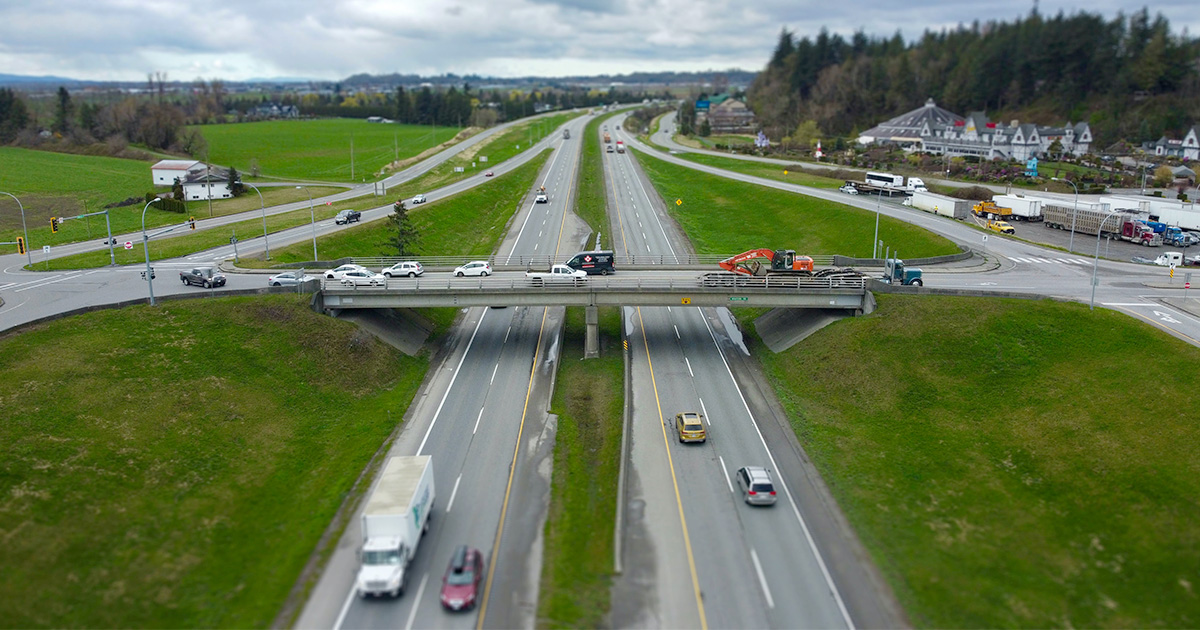 Photo of Whatcom showing four lanes of traffic flowing underneath overhead bridge