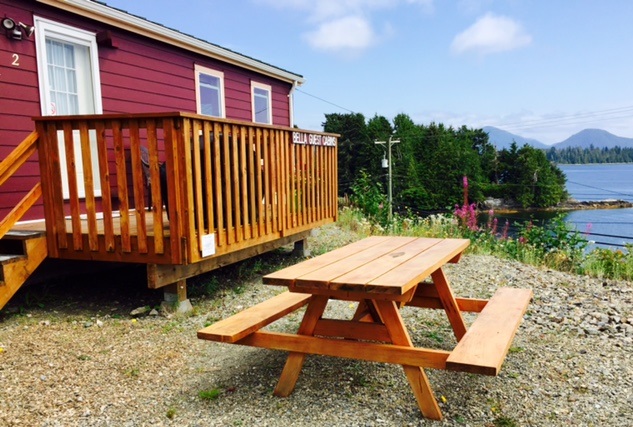 Picnic table outside of red ocean-side cabin