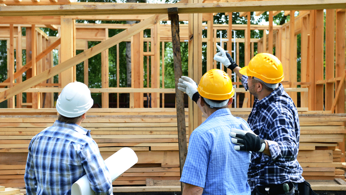 construction workers pointing to a wooden structure