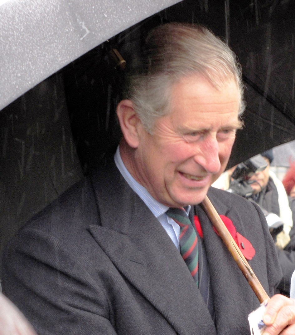 Prince Charles braves the rain to speak to members of the public