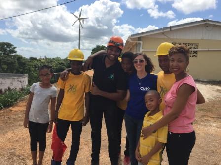 BC Public Servant, Christine French at her CUSO placement. Christine stands with seven other people in front of a house in Jamaica.