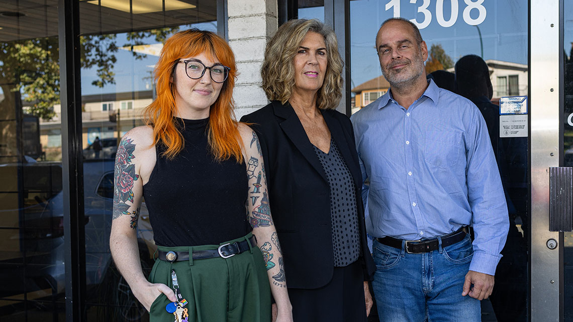 Three people standing outside a Community Corrections office