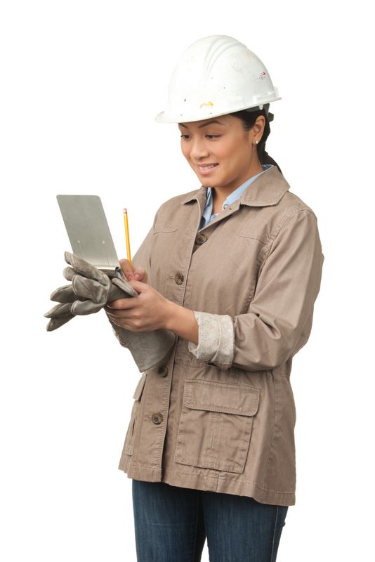 Woman in hard hat writing on clipboard