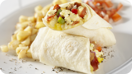 Close up of a breakfast burrito with scrambled eggs and vegetables.