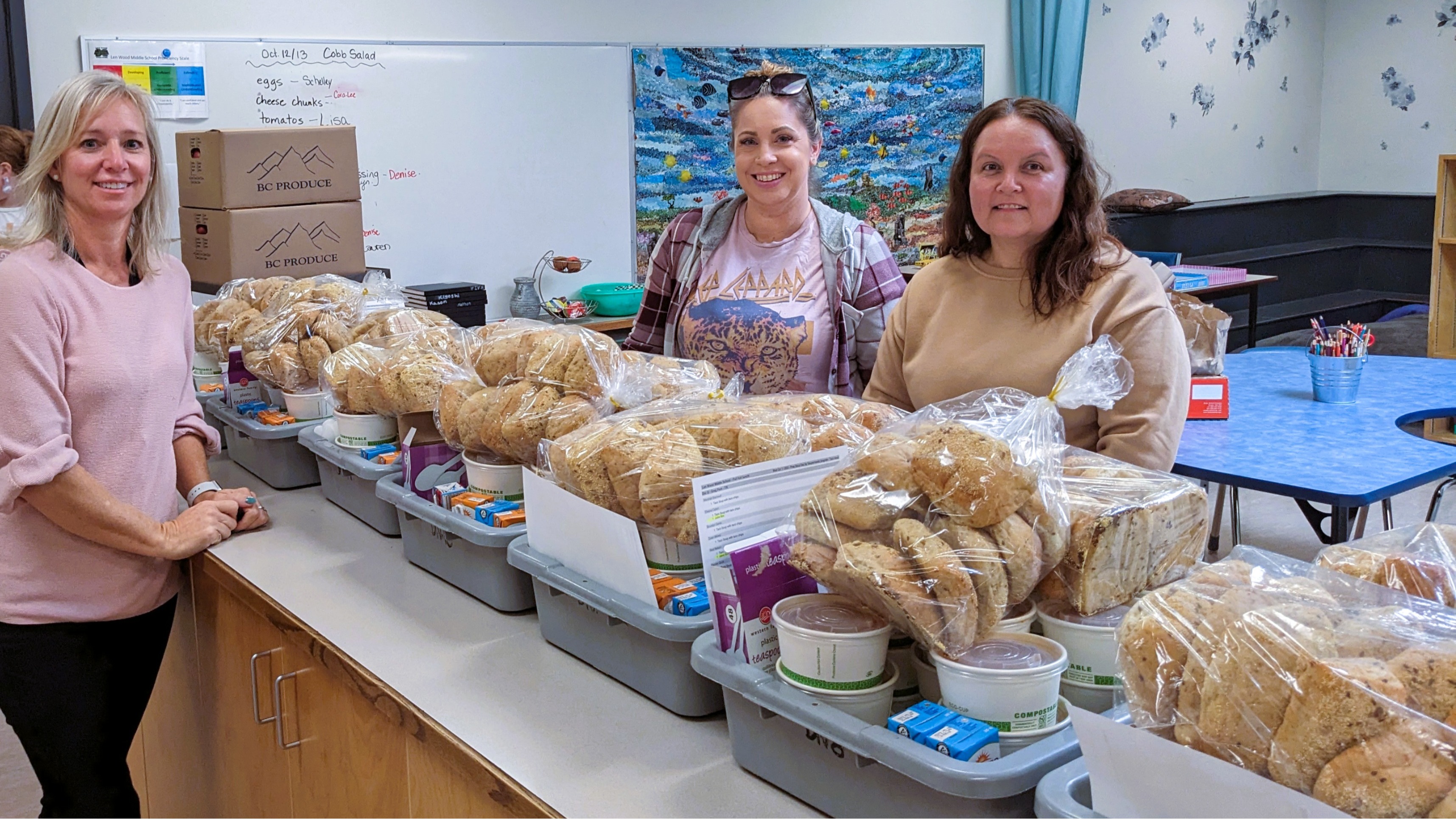 Buns, cups of soup and juice boxes organized in bins for classrooms with staff.