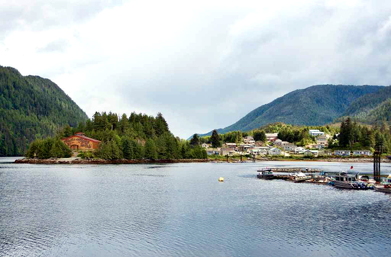 Small community on the water, with boats docked and hills in the background