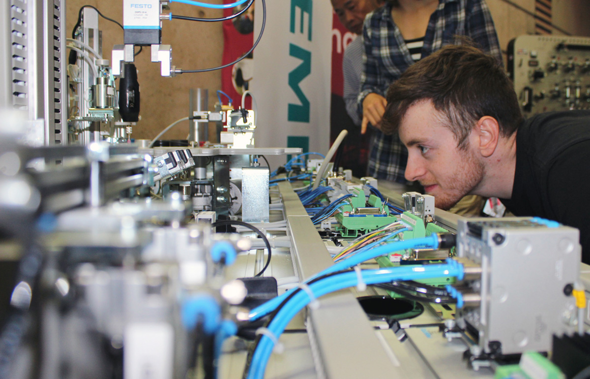 student looking at machine parts