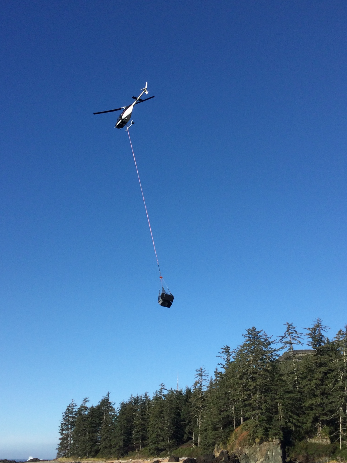 Helicopter air lifting fridges off the beach
