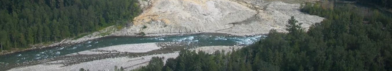 Banner photo of a flowing river with rocky hills and forests