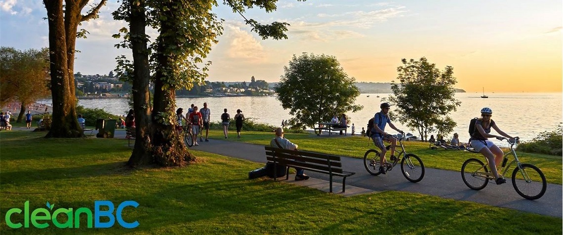 people walking and cycling along a park path close to the water