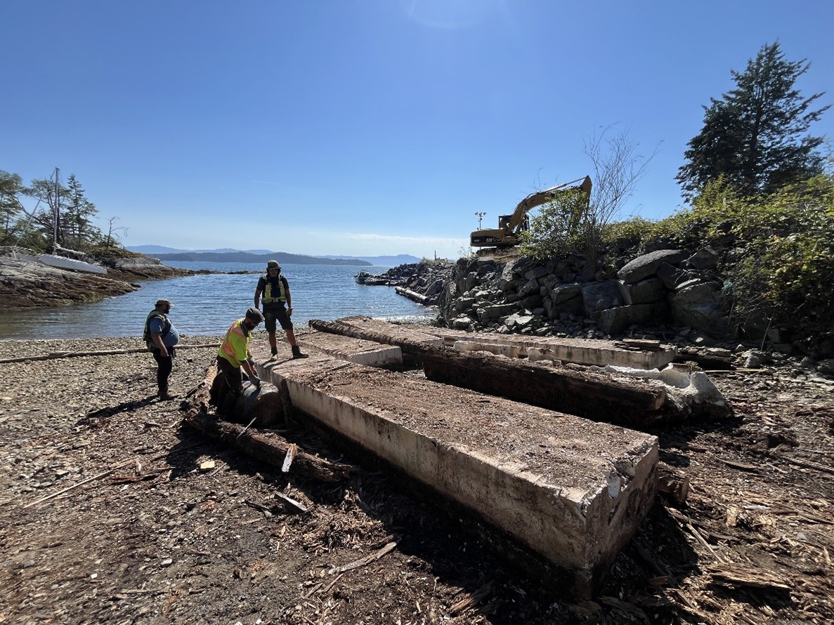 Persons inspecting derelict material on shore