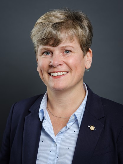 Headshot of Josie Osborne, Minister of Energy, Mines and Low Carbon Innovation. She is a middle-aged Caucasian woman with short, cropped blonde hair. She is wearing a light-blue collared shirt and dark-blue blazer.