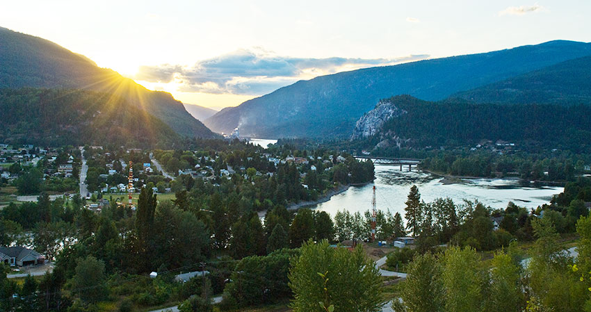 an image of castlegar and river at sunset