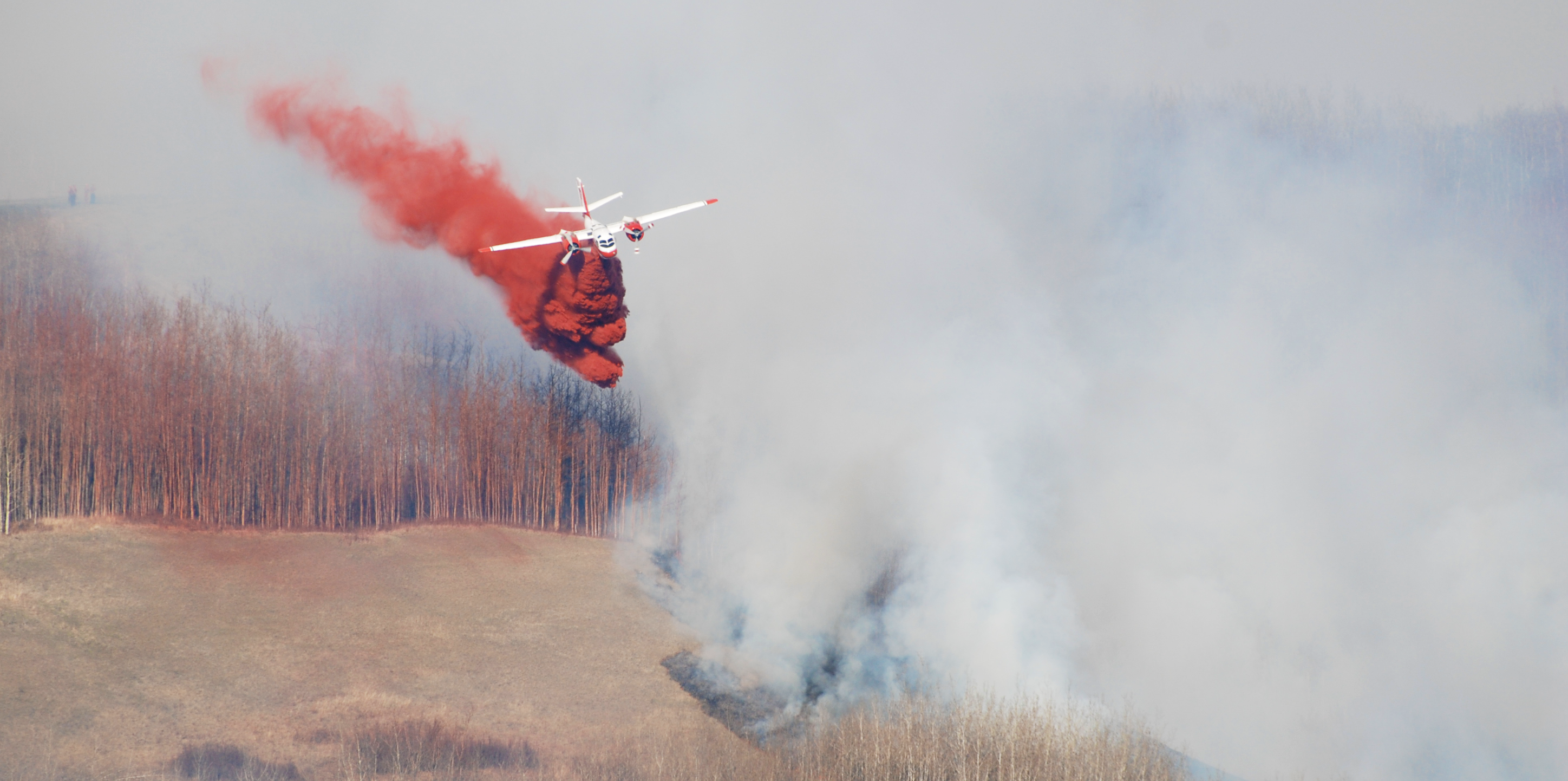 bc wildfire service air tanker dropping retardant near a wildfire
