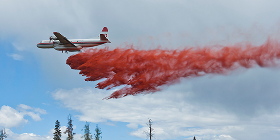 BC Wildfire Service airtanker drops fire retardant near a wildfire