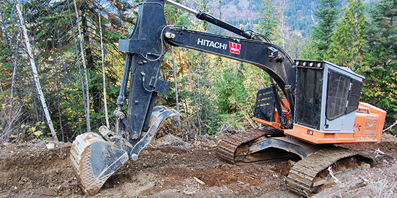 Excavator working on a fire guard for the BC Wildfire Service